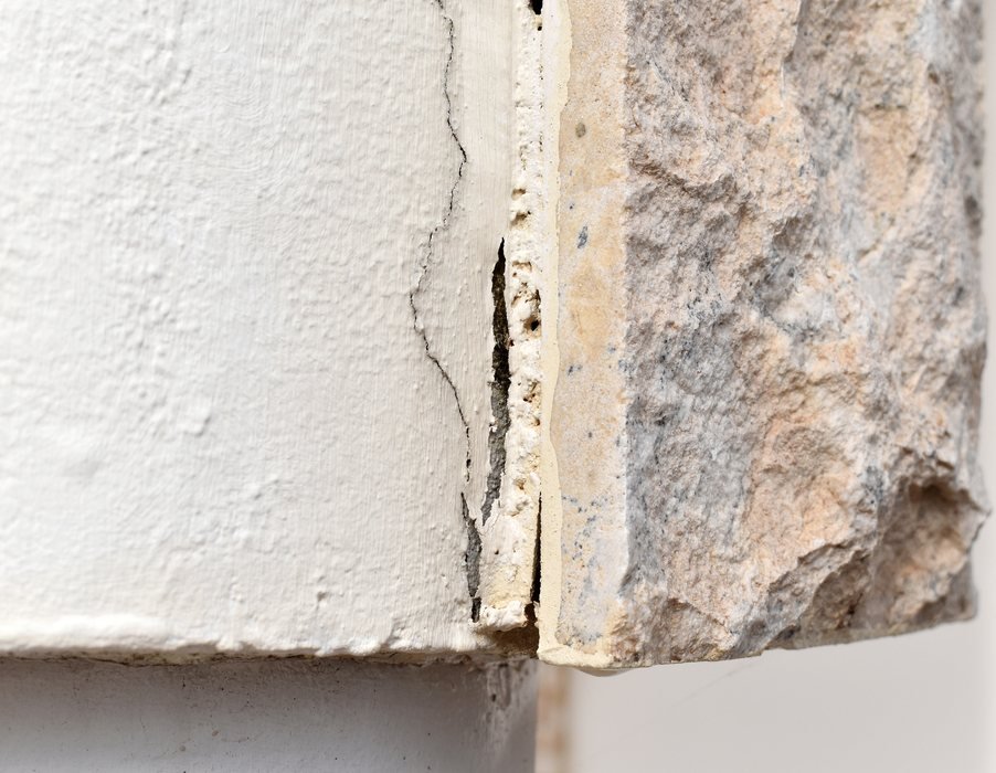 Detalhe de parede de concreto aparente com fissura visível na superfície