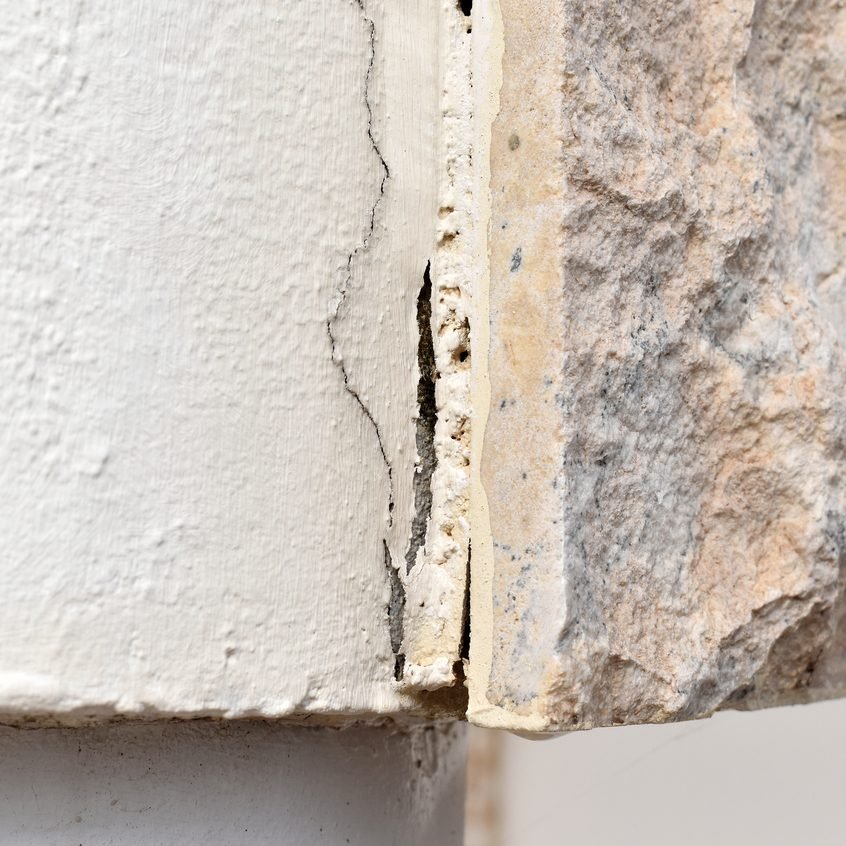 Detalhe de parede de concreto com fissura aparente na superfície