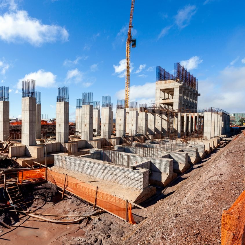 Canteiro de obras com pilares de concreto e fundações em execução